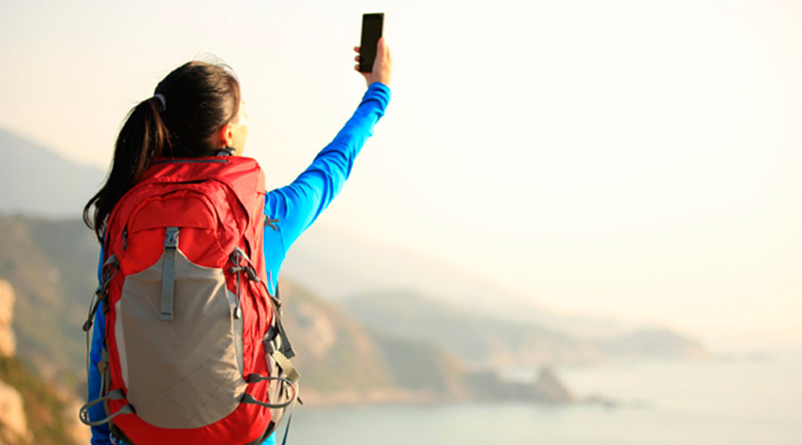 Mujer buscando señal en la montaña