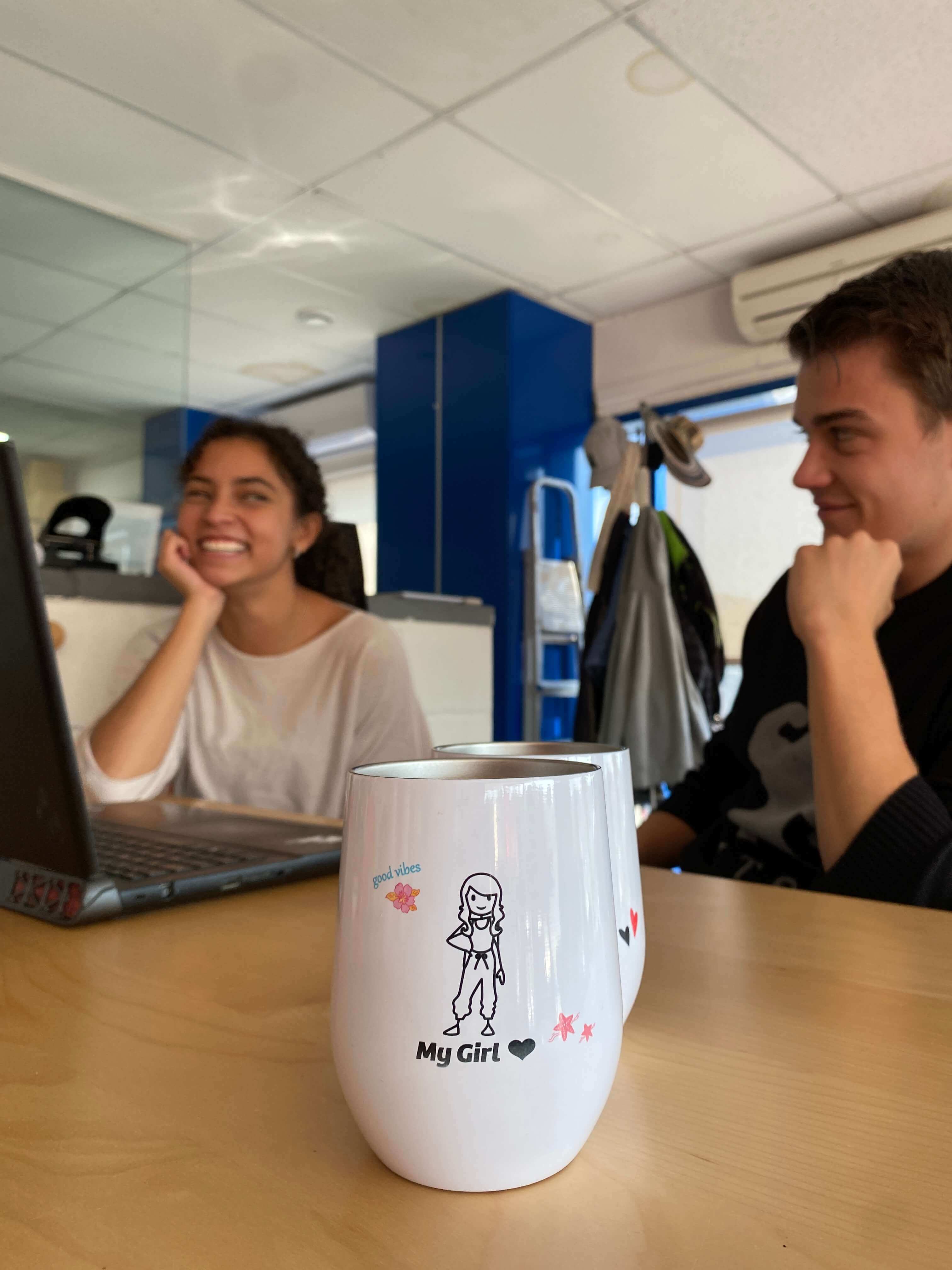 Couple with personalised thermal coffee mug looking at each other